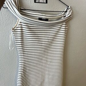 It’s a pretty little balnche and black dress with a boat neck. It is elegant.